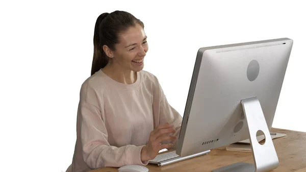 Mujer feliz teniendo una videollamada sentada frente a su computadora sobre fondo blanco. — Foto de Stock