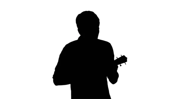 Silhouette Young man playing ukulele and signing while walking. — Stock Photo, Image