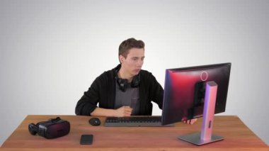 Gergin adam gradyan arka planda bilgisayar üzerinden video oyunları izliyor..