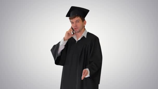 身着长袍的男性毕业生和在梯度背景下通过电话交谈的凡人. — 图库视频影像