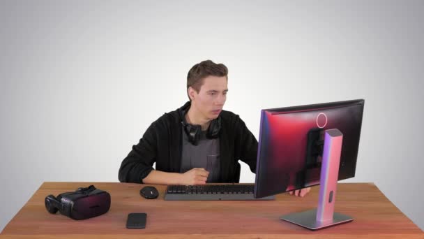 Uomo nervoso che guarda videogiochi su un computer PC su sfondo sfumato. — Video Stock