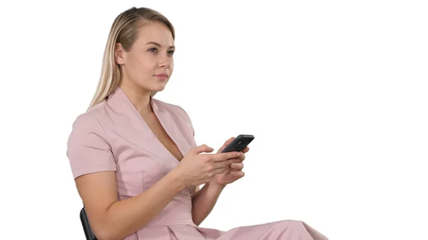 Sorrindo mulher loira sentado e usando smartphone em branco backg — Fotografia de Stock