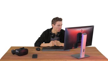 Ciddi bir oyuncu bilgisayar başında oturmuş beyaz sırtında maç izliyor.