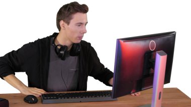 Gergin adam beyaz sırtlı bir bilgisayardan video oyunu izliyor.
