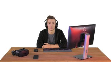 Kulaklık takmış genç bir adam kameraya beyazların arkası hakkında konuşma yapıyor.