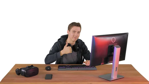 Young gamer shows a thumbs up and looks into the camera on white — Stock Photo, Image