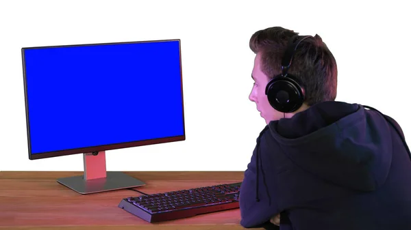 Профессиональный геймер смотрит на свой персональный компьютер на белом коврике — стоковое фото