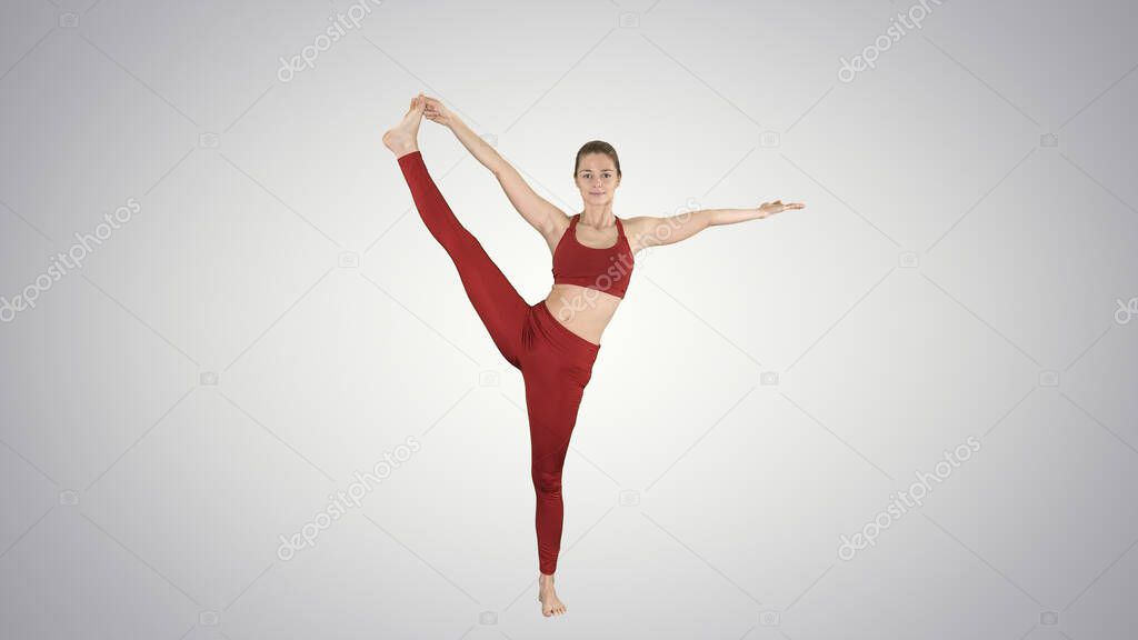 Young woman practicing yoga, standing in Utthita Hasta Padangust