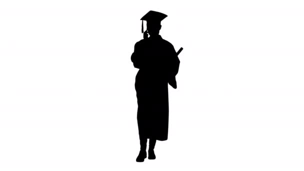 Silhouette Happy estudiante femenina en bata de graduación hablando emocionalmente por teléfono mientras camina con diploma. — Vídeos de Stock