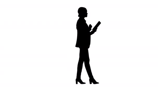 Silhouette Businesswoman using a tablet pad while walking. — Stock Video
