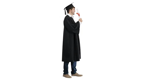 Усміхнений студент чоловічої статі у випускному халаті позує з дипломом на w — стокове фото