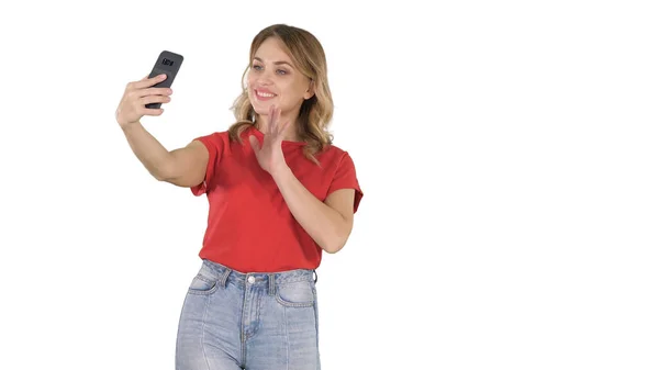 Nettes Mädchen macht Selfie zu Fuß auf weißem Hintergrund. — Stockfoto