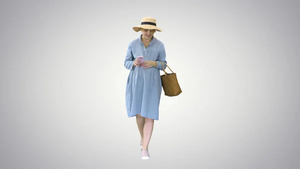 Jovem grávida em chapéu da moda andando e usando seu telefone o — Fotografia de Stock