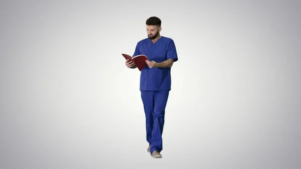 Medico lettura rivista medica mentre si cammina su dorso gradiente — Foto Stock