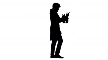 Saray mensubu gibi giyinmiş Siluet Adam konuşuyor ve yürürken ellerini sallıyor ve kameraya bakıyor..