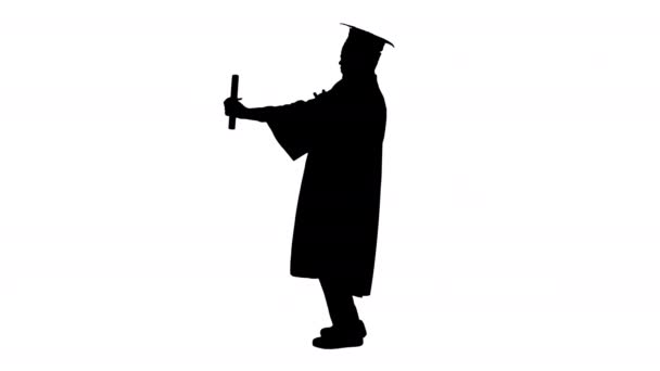 Silhouet Gelukkig Afrikaans amerikaanse mannelijke student in graduation robe poseren met diploma voor camera. — Stockvideo