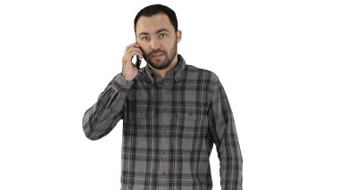 Genç adam telefonda konuşuyor ve beyaz arka planda yürüyor..