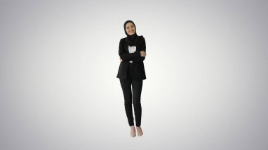 Kameraya poz veren tesettürlü gülümseyen Arap iş kadını.