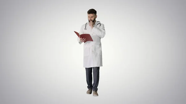 Medico che legge un libro o un diario mentre cammina sul gradiente bac — Foto Stock