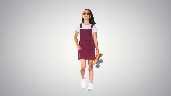 För cool-för-skolan asiatiska skridskoåkare flicka promenader på lutning backgr — Stockfoto