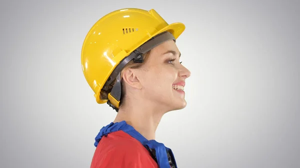 La giovane donna ingegnere con casco di sicurezza giallo a piedi e s — Foto Stock
