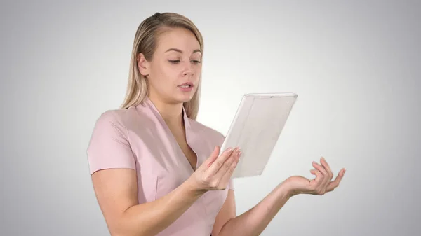 Happy woman chatting over a video call, by using a tablet on gra — Stock Photo, Image