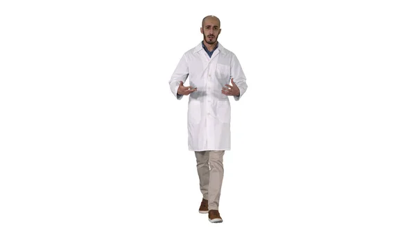 Vriendelijke mannelijke arts lopen en praten op zoek in camera op witte achtergrond. — Stockfoto