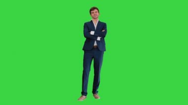 Yakışıklı genç işadamı kollarını kavuşturmuş, yeşil ekranda güvenle gülümsüyor, Chroma Key.