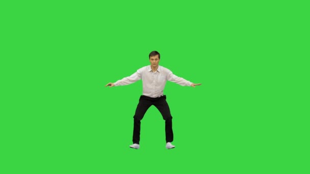 Jongeman in wit shirt danst een moderne dans met gebogen armen op een groen scherm, Chroma Key. — Stockvideo