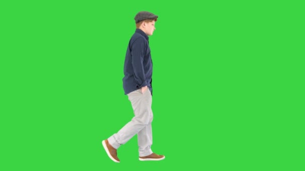 Stylish teenage boy in a shirt and a cap walking on a Green Screen, Chroma Key. — Stock Video