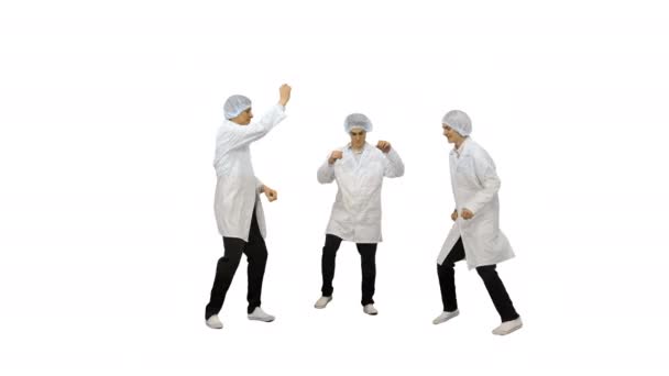 Tre manliga läkare i vita morgonrockar och skyddshattar gör roliga fest dans på vit bakgrund. — Stockvideo