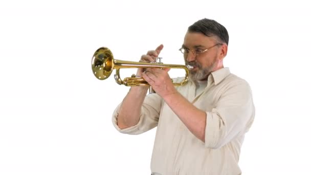 Old man in glasses playing trumpet on white background. — Stock Video