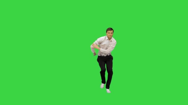 Молодой человек в белой рубашке и черных штанах танцует брейк-данс на Зеленом экране, Chroma Key. — стоковое видео