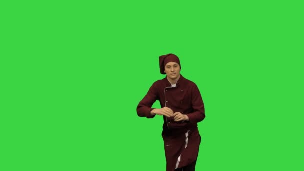 Mannelijke chef-kok in rood uniform break dansen met een spatel tegen groene achtergrond op een groen scherm, Chroma Key. — Stockvideo
