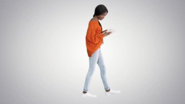 Gradyan üzerinde yürürken tablet bilgisayar kullanan gülümseyen Afrikalı Amerikalı kadın.