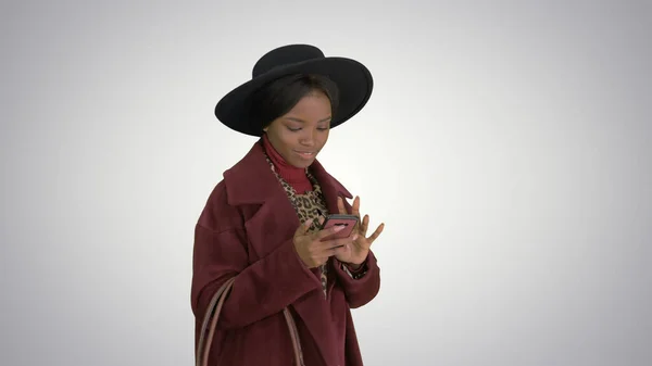 Hermosa chica de moda afroamericana en abrigo y sombrero negro te — Foto de Stock