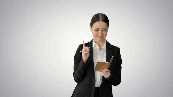 Skoncentrowana kobieta w garniturze pisząca pomysły na biznes w notatce — Zdjęcie stockowe