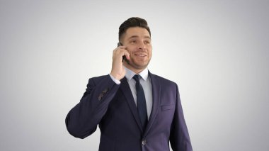 Gülümseyen genç işadamı cep telefonuyla arıyor.