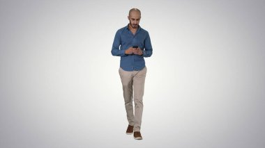 Gradyan arkaplan üzerinde yürürken mesaj gönderen adam.