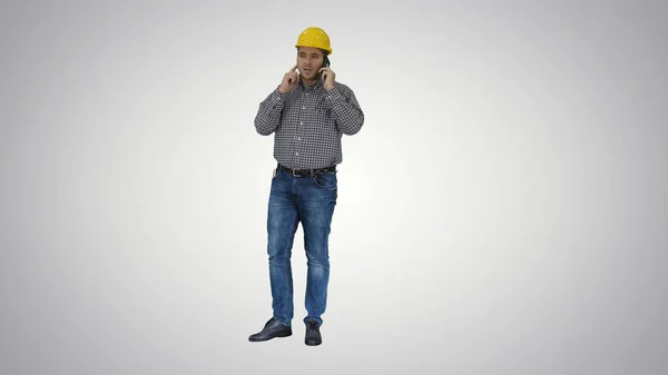 Travailleur de la construction utilisant un smartphone sur fond dégradé. — Photo