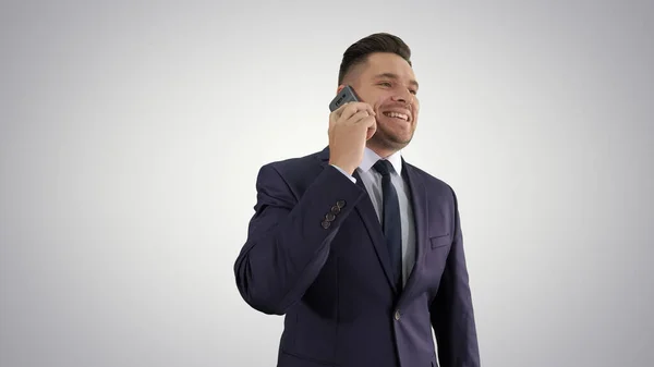 Empresario hablando por teléfono móvil felizmente en gradiente backgrou — Foto de Stock