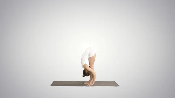 Vacker modell som tränar yoga stående i Uttanasana med — Stockfoto