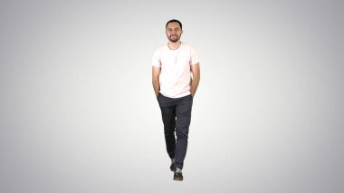 Kendine güvenen genç bir adam ileri yürüyor ve kameraya bakıyor.