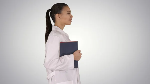 Gelukkig glimlachende vrouwelijke arts lopen met notebooks of documen — Stockfoto
