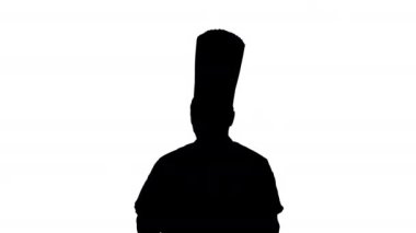 Siluet çekici aşçı elinde pizzayla yürüyor ve kamerayla konuşuyor..