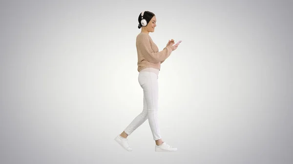 Glückliches Mädchen zu Fuß Musik hören mit Smartphone trägt h — Stockfoto