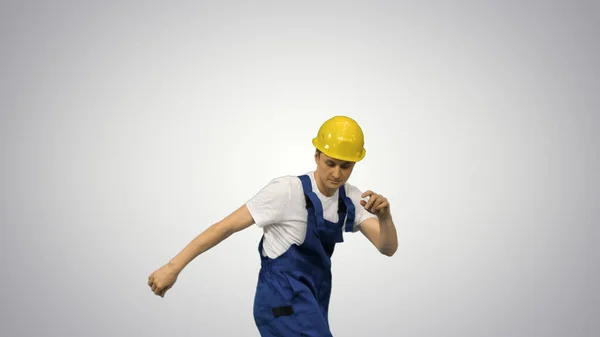 노랗고 단단 한 모자를 쓰고 춤을 추는 젊은 건축 봉사자 — 스톡 사진