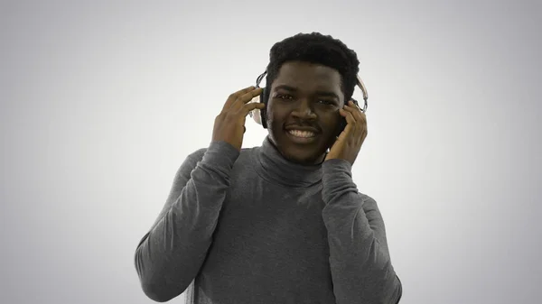 Glad afroamerikan som håller i hörlurar med händerna och Dan — Stockfoto