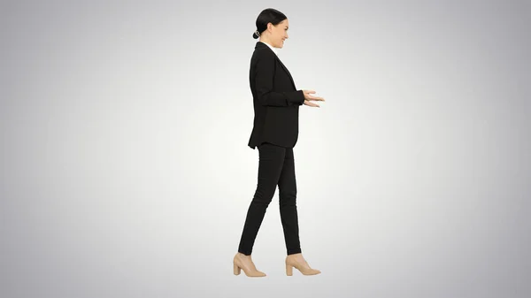 Uśmiechnięta bizneswoman wyjaśniając i gestykulując podczas chodzenia — Zdjęcie stockowe