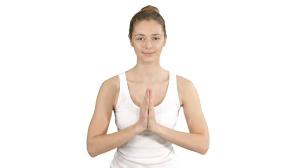 Молодая женщина йога практикует йогу, делает жест намасте, тренируется, носит белую футболку на белом фоне. — стоковое фото